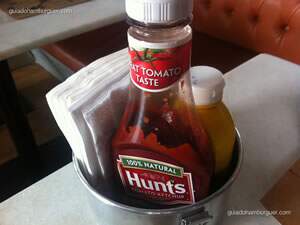 Ketchup Huntes, mostarda Heinz e guardanapo em uma marmita de alumínio - meats