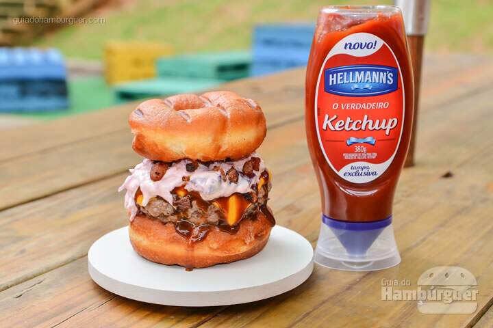 The Original Donut Burger: Hambúrguer artesanal de 130g, queijo cheddar, molho barbecue, bacon grelhado, coleslaw (salada de maionese americana) em um donut (com ou sem cobertura doce). - R$ 20 - SP Burger Fest