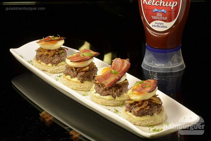 Mini Número Burger: Mini burger de angus, com queijo cheddar, crispy de cebola, ovinhos estrelados e crocante de bacon sobre torradinha de pão miga - R$ 42 - SP Burger Fest