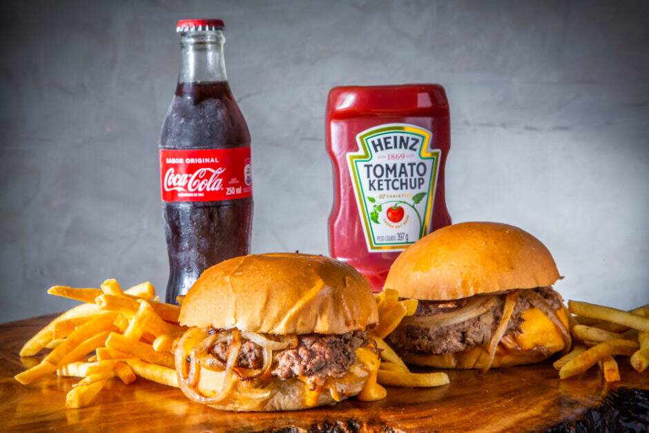 Amburgui Original: Pão Briochinho, 2 smash de 60g cada, 40g de American Cheese, Molho do Mês.