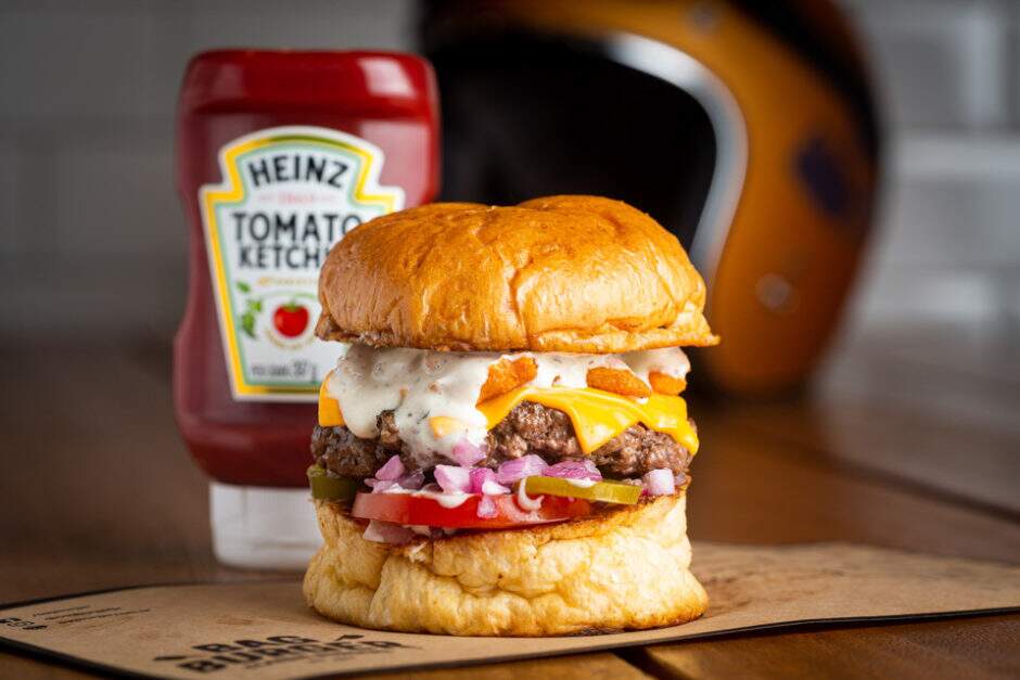 Burger artesanal, queijo cheddar, molho ranch, picles de pimenta jalapeño, nacho artesanal, tomate e cebola roxa, no pão de batata.