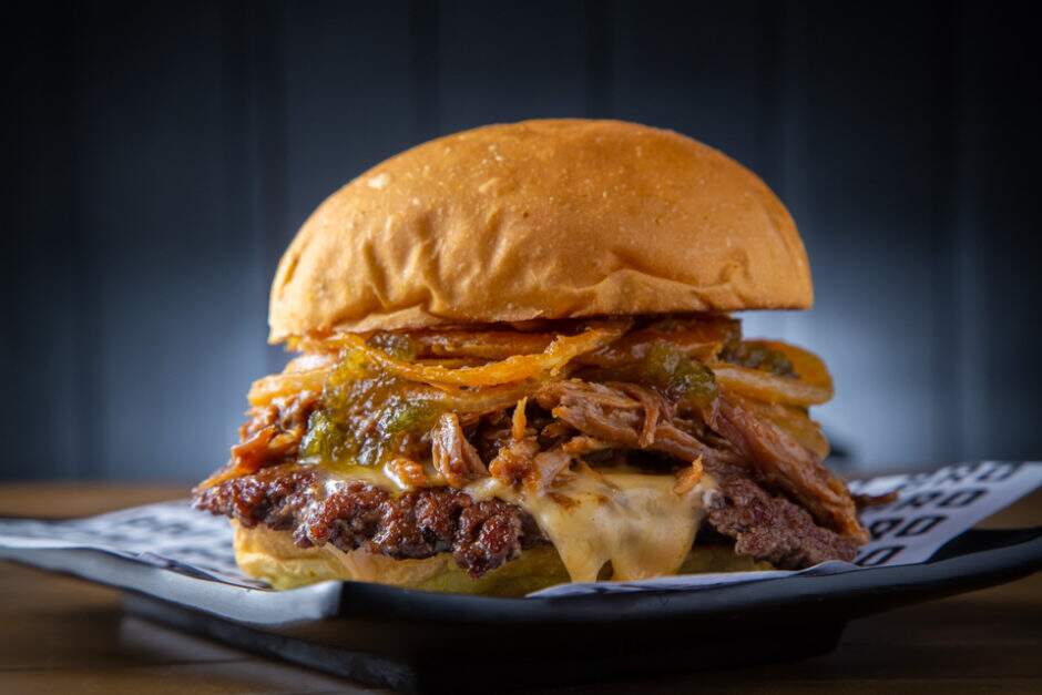 Burger smash, american cheese, pulled pork defumado, cebola crispy e relish de pepino no potato roll.