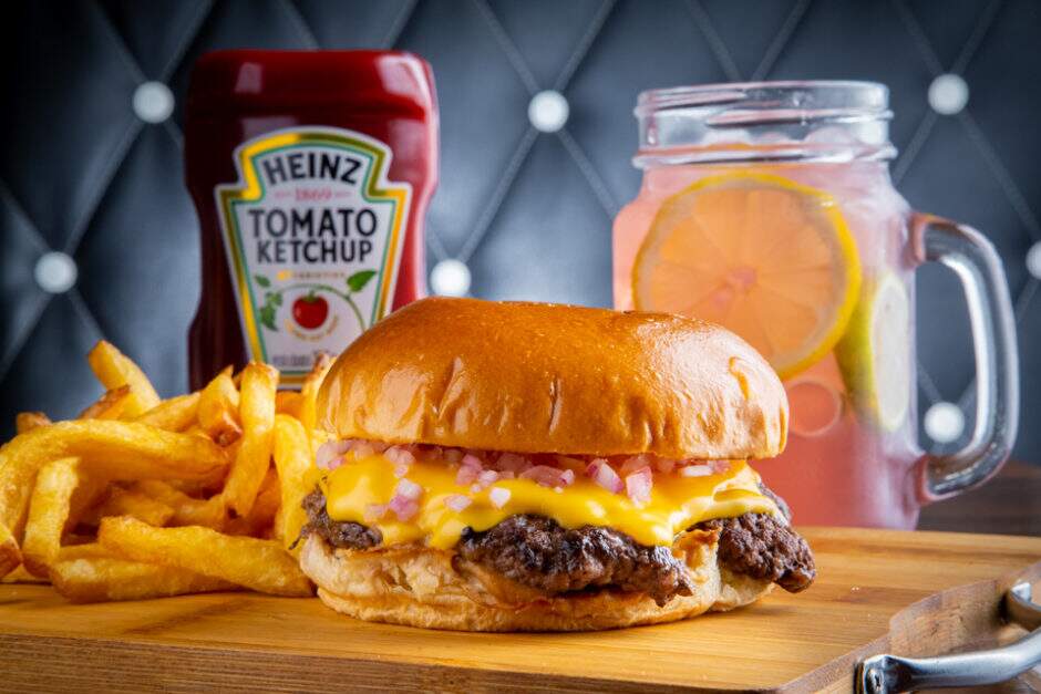 Smash Burger de Angus de 90g, Molho Especial elaborado com base na Maionese do Chef Heinz e Cebola Roxa Picada no Pão de Brioche. Acompanha Happens Fries e Pink Lemonade.