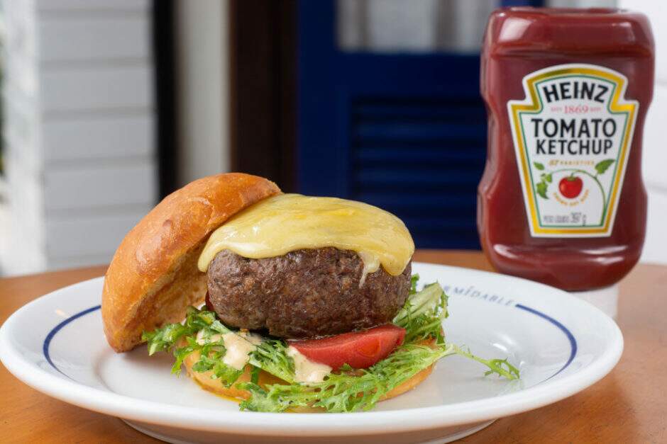 Pão de burguer selado, 180 gramas de carne black Angus, queijo gruyere, molho Dijon, chicória frisée temperada e tomate confit.