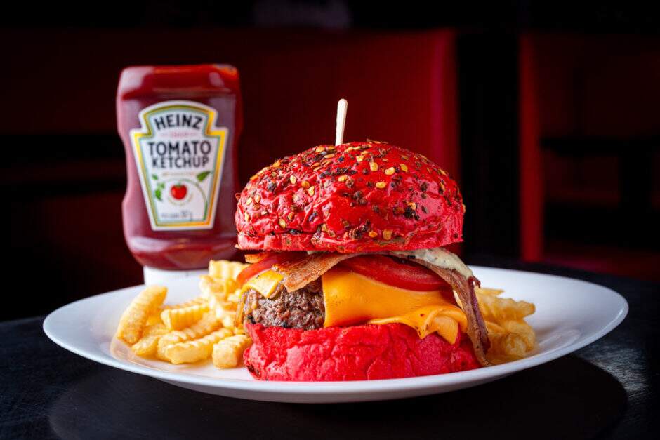 Pão de pimenta (ou tradicional), burger blend bovino, cebolas marinadas ao barbecue, fatias de cheddar derretidas no vapor, fartas fatias de bacon, tomate e maionese de majericão.
