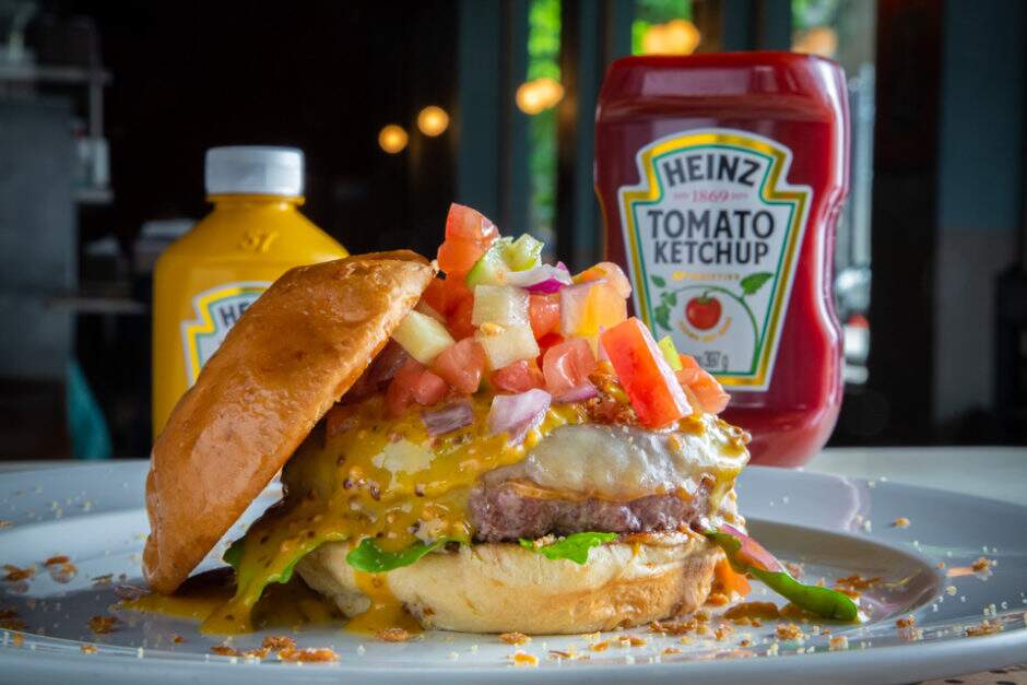 Brioche de mandioquinha, burger de 180g, provolone, rúcula selvagem, vinagrete com picles de maçã e Meats honey & Mustard.