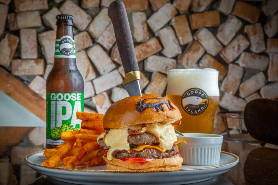 2 hambúrgueres, cheddar, bacon, tomate e molho especial. Acompanha Papas Bravas e Maionese Aioli