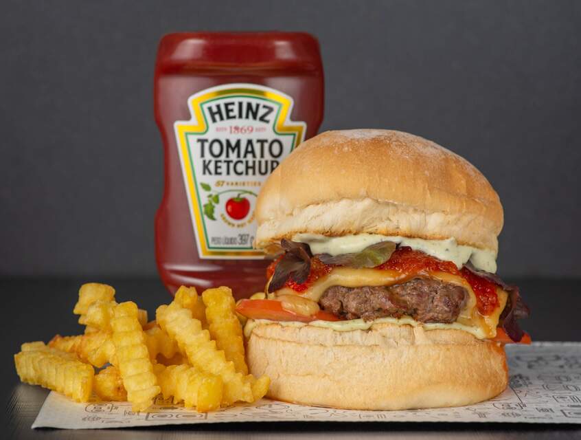 Pão de aipim, maionese de manjericão, burger de 180g de carne ou vegetariano, triplo queijo provolone, geleia de pimenta, tomate e alface frisê. Acompanha batatas e maionese.