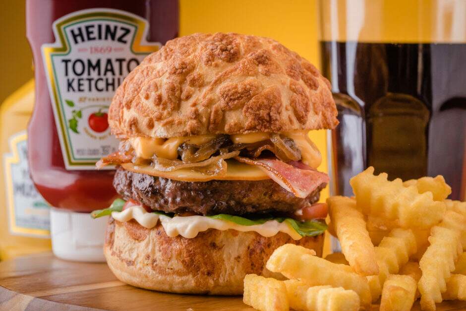 Villa Madalena ( hambúrguer premiado pelo bom gourmet da gazeta do povo, como melhor burguer de Curitiba, pão com lascas de queijo provolone, hambúrguer artesanal, queijo provolone fatiado, bacon em tiras, cebola caramelizada, rúcula, tomate cereja, maionese e molho especial). Acompanha porção de fritas individual e refrigerante lata 220 mls.